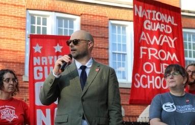 Robert looking to his right at rally protesting federal interference in local education.