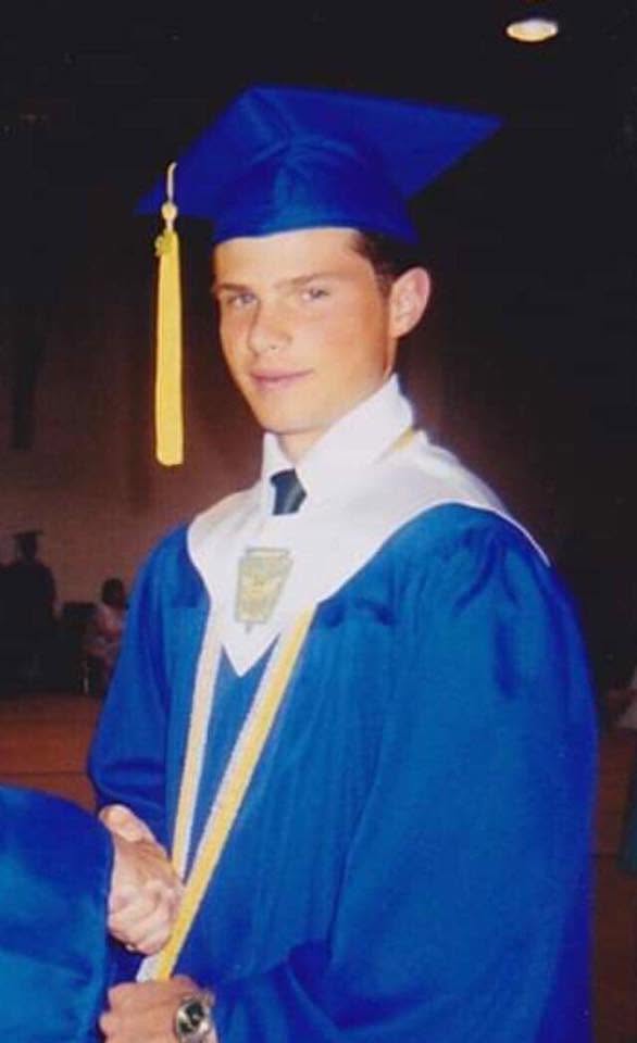 Robert in blue cap and gown after high school graduation.