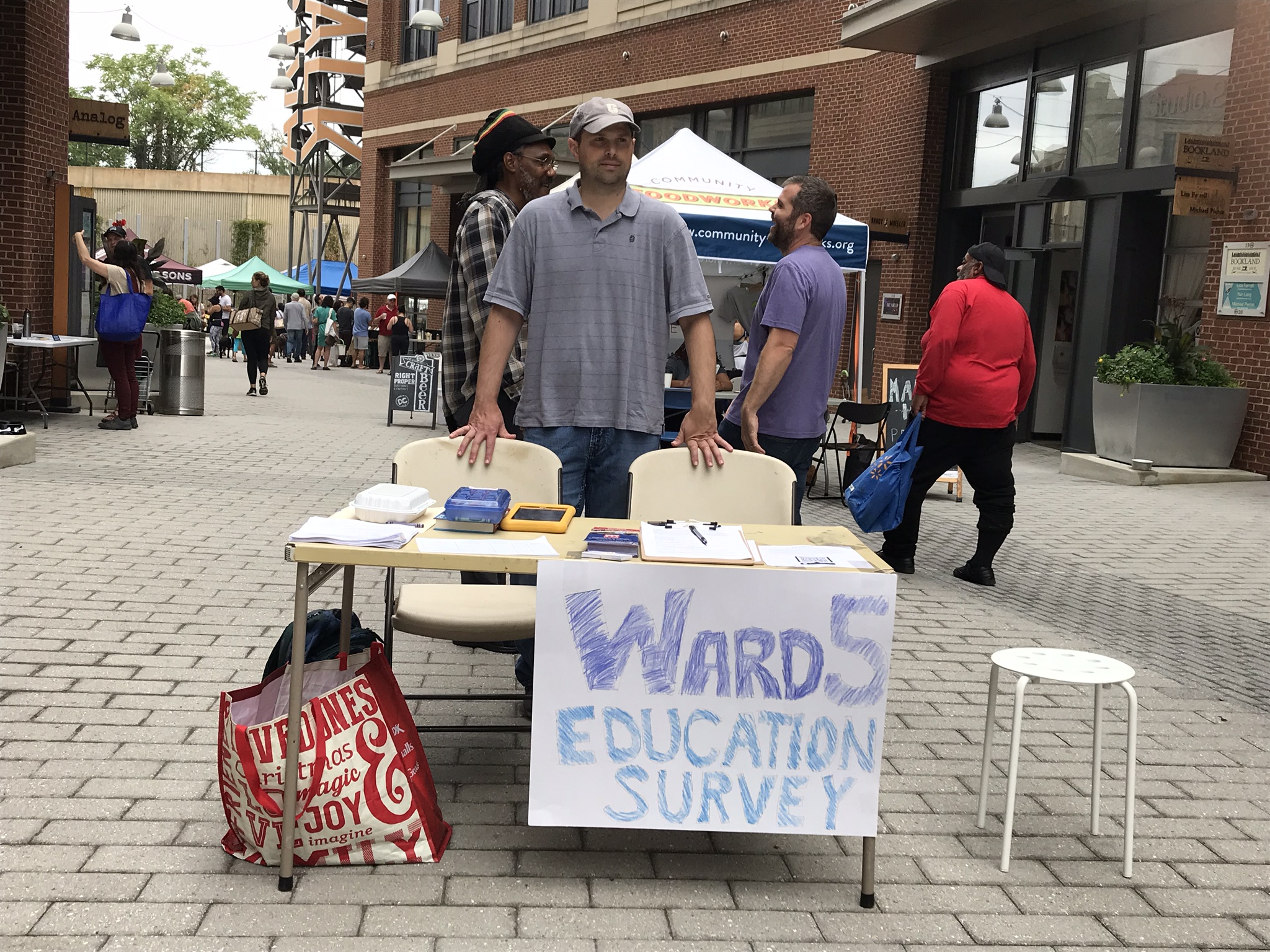 Robert stands behind a table with sign 